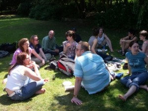 Some Pink Singers sitting on the grass having a picnic